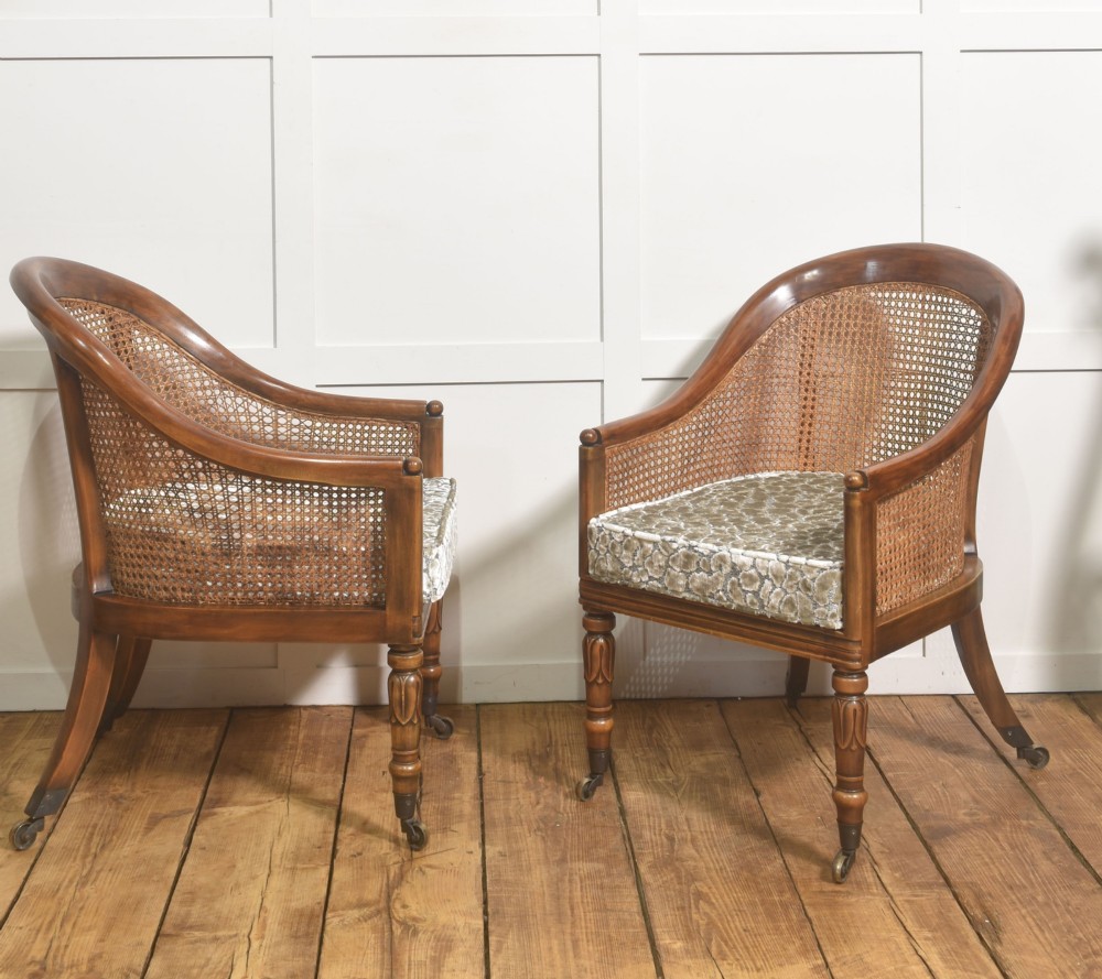 Pair of Regency style mahogany tub chairs featuring woven cane backs, upholstered cushions, turned legs, and brass castors. View VI
