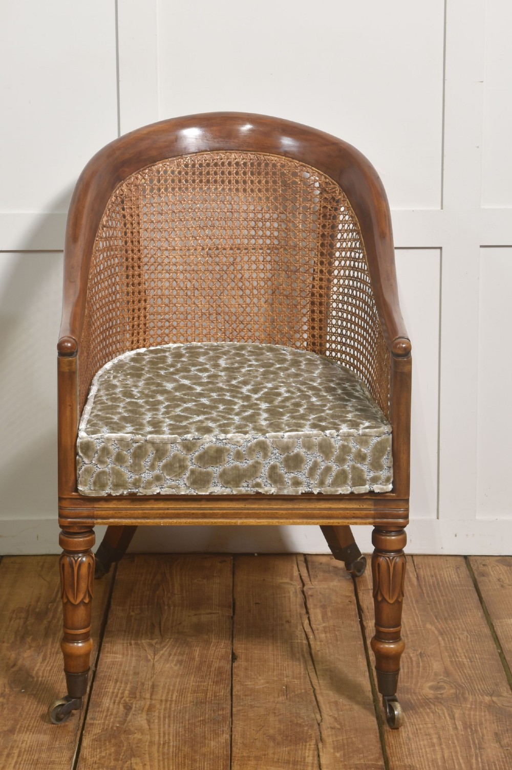 Pair of Regency style mahogany tub chairs featuring woven cane backs, upholstered cushions, turned legs, and brass castors. View VIII