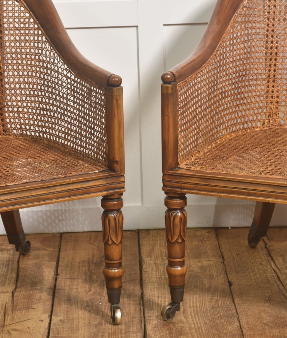 Pair of Regency style mahogany tub chairs featuring woven cane backs, upholstered cushions, turned legs, and brass castors. View XIII