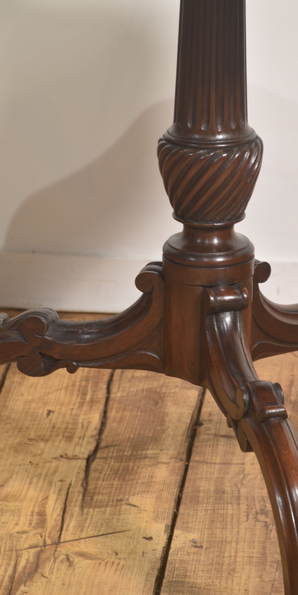 A dark carved mahogany tripod occasional table featuring a scalloped piecrust top, fluted central pedestal, and carved cabriole legs. View III
