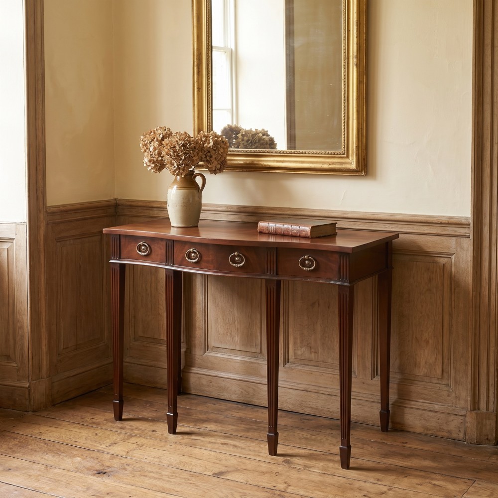 An Edwardian mahogany bow-fronted side table featuring four drawers with brass ring handles and slender fluted legs ending in spade feet. View II