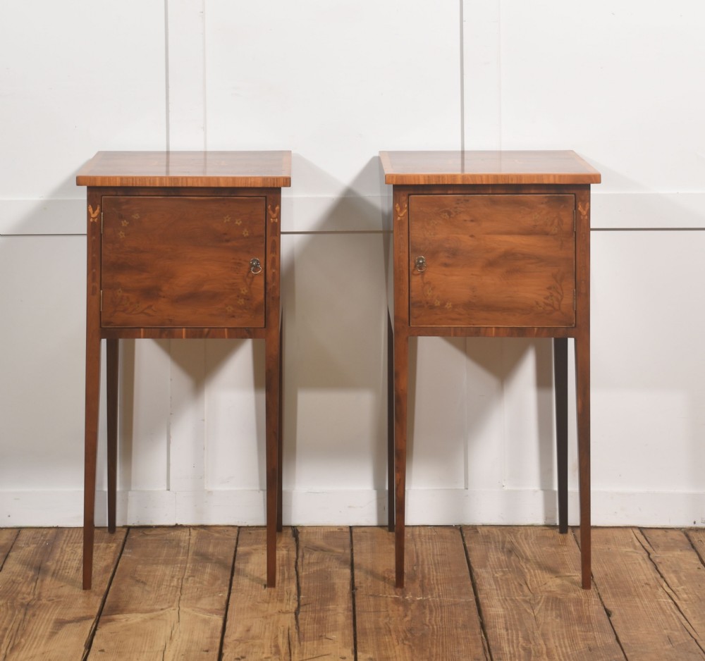 A matching pair of tall, slim mahogany Sheraton style bedside cabinets featuring floral marquetry inlay on single cupboard doors and square tapered legs.