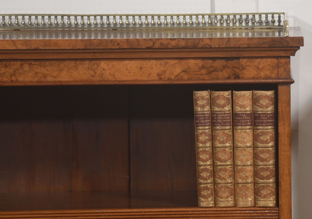 A pair of low burr walnut open bookcases featuring brass galleries along the top and adjustable interior shelves. View II