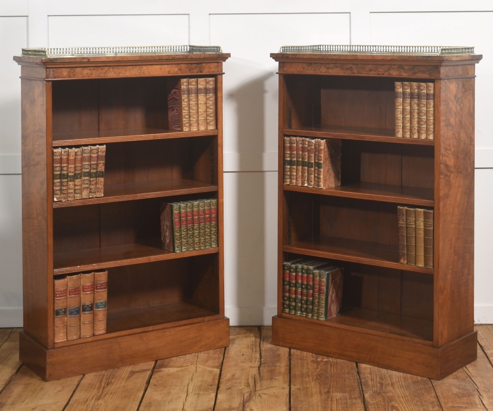 A pair of low burr walnut open bookcases featuring brass galleries along the top and adjustable interior shelves. View V