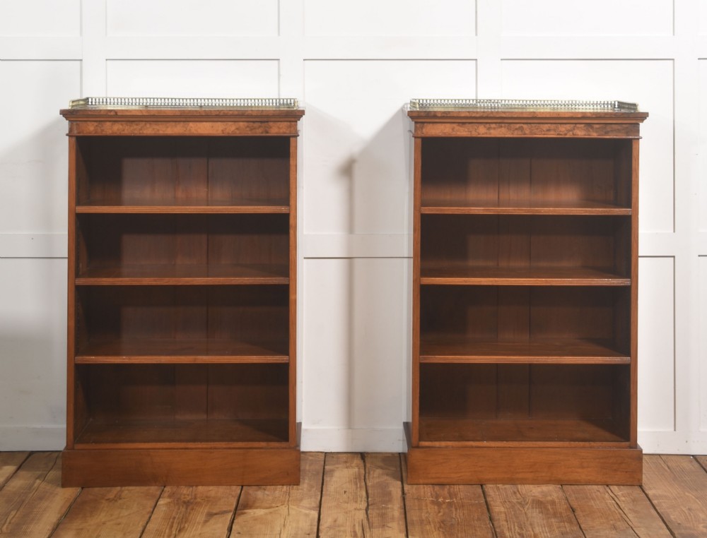 A pair of low burr walnut open bookcases featuring brass galleries along the top and adjustable interior shelves. View VI