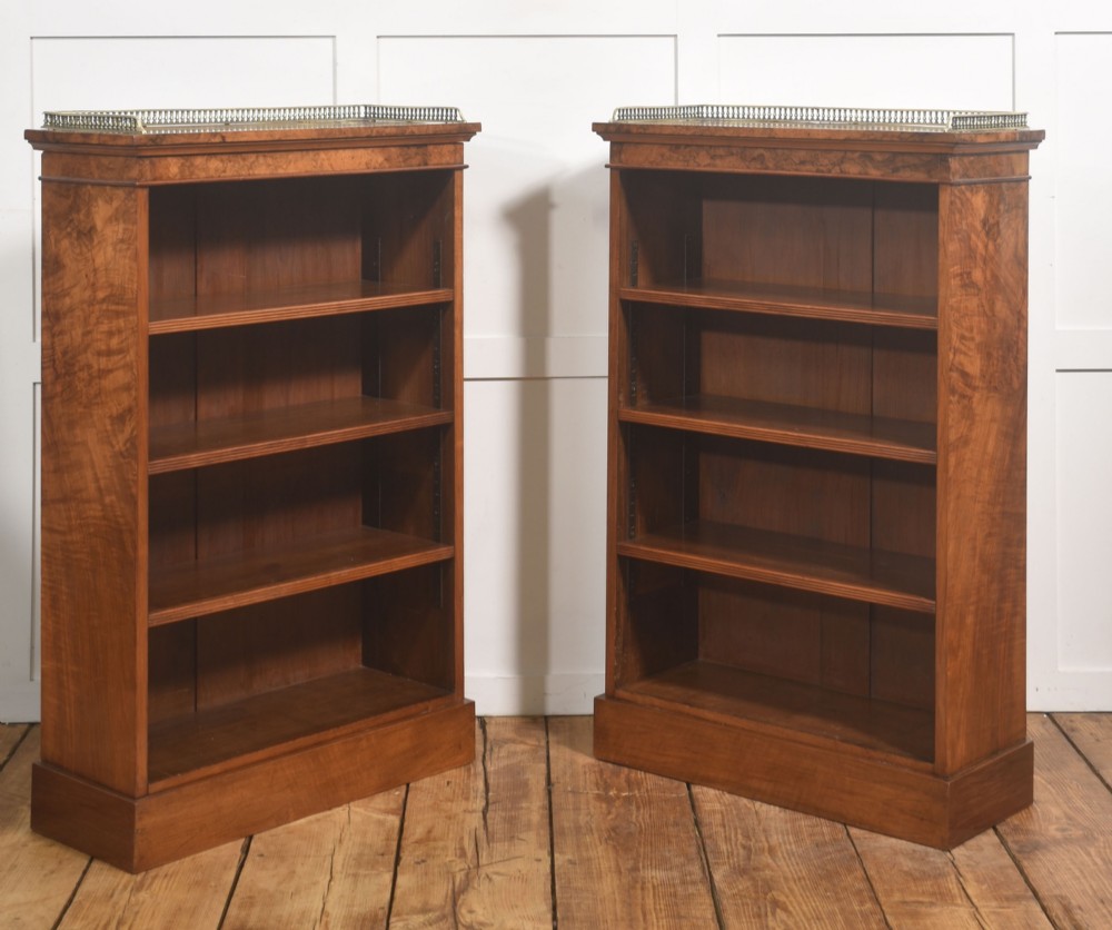 A pair of low burr walnut open bookcases featuring brass galleries along the top and adjustable interior shelves. View VII