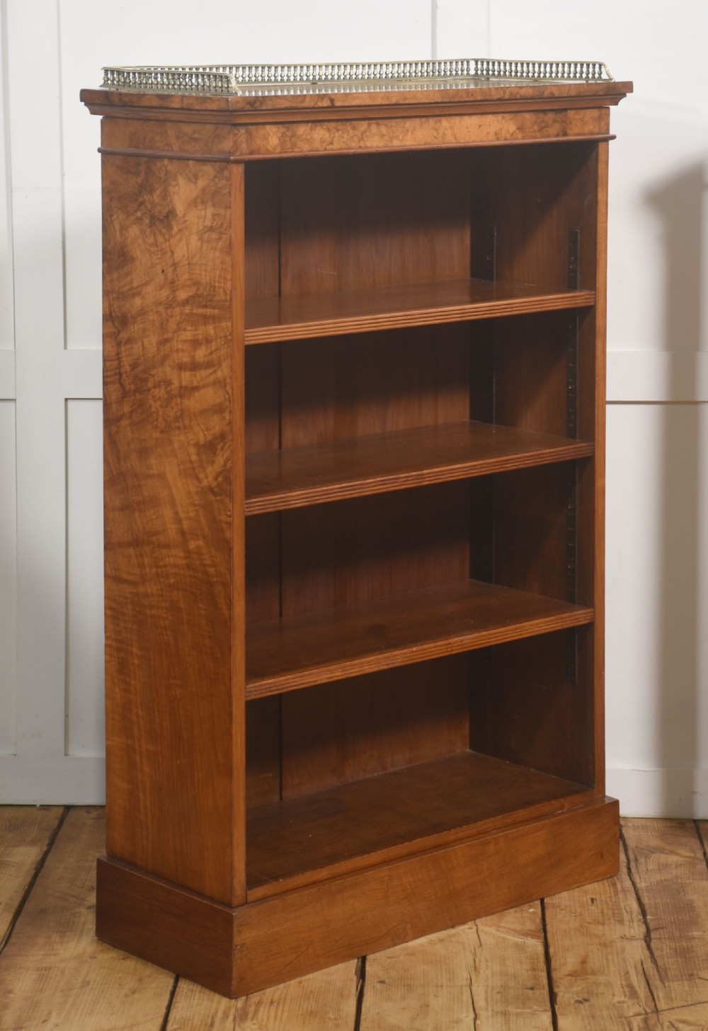 A pair of low burr walnut open bookcases featuring brass galleries along the top and adjustable interior shelves. View X