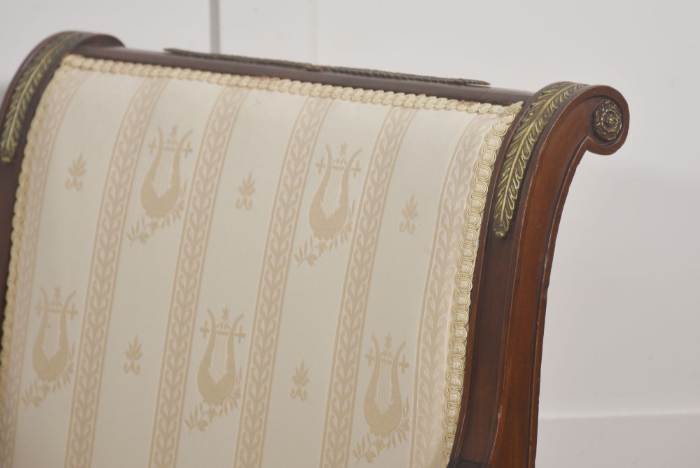 An Empire style mahogany armchair featuring cream upholstered silk fabric with lyre motifs, winged sphinx arm supports, and gilt brass winged lion front legs. View XI