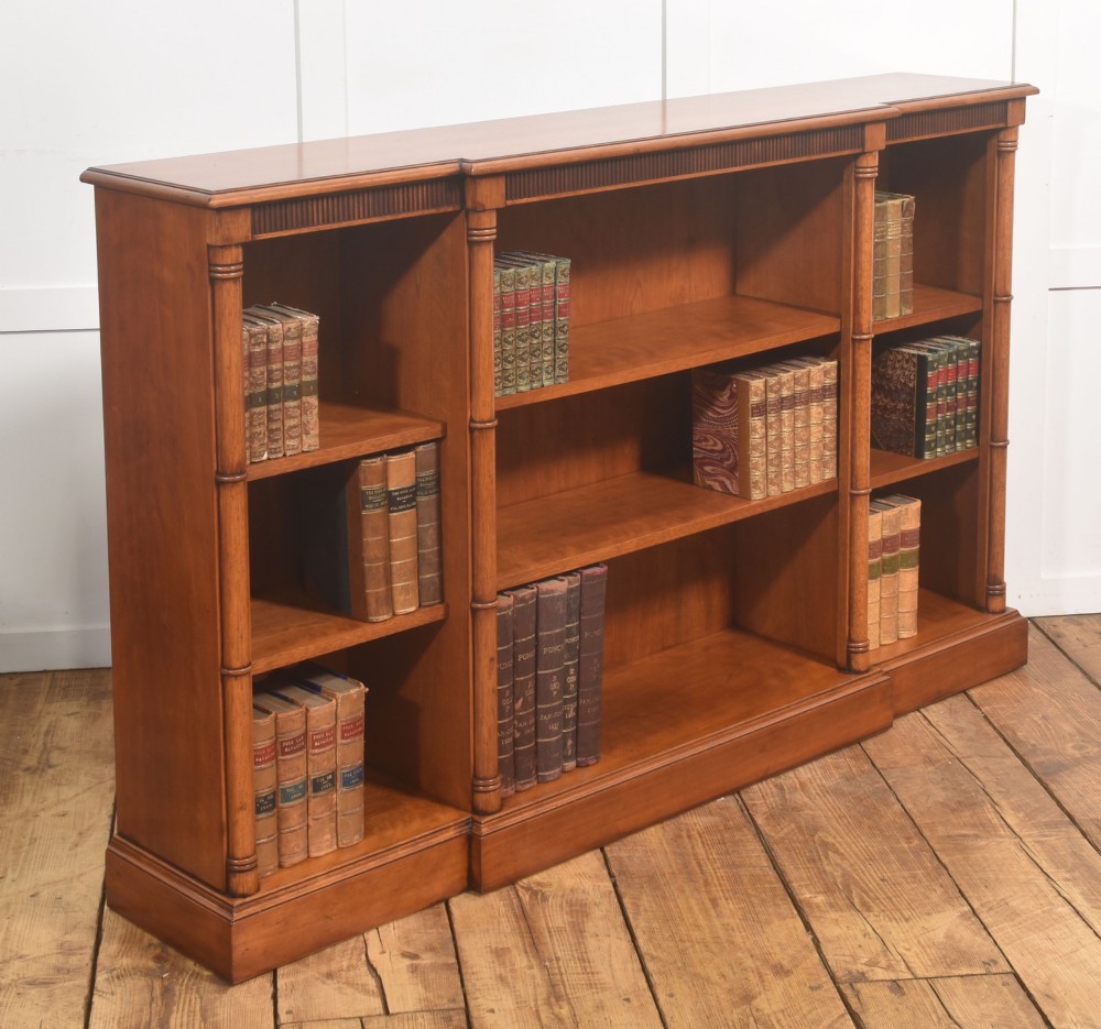 A low Regency style mahogany breakfront open bookcase featuring three shelving sections separated by reeded pilasters. View IV