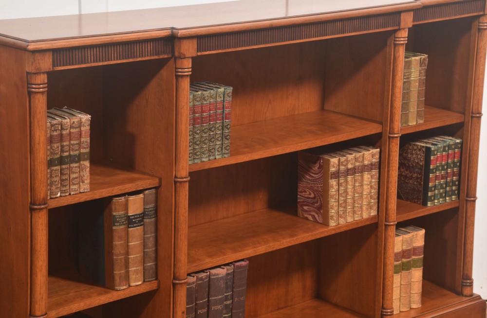 A low Regency style mahogany breakfront open bookcase featuring three shelving sections separated by reeded pilasters. View V