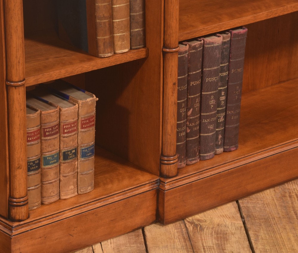 A low Regency style mahogany breakfront open bookcase featuring three shelving sections separated by reeded pilasters. View VI