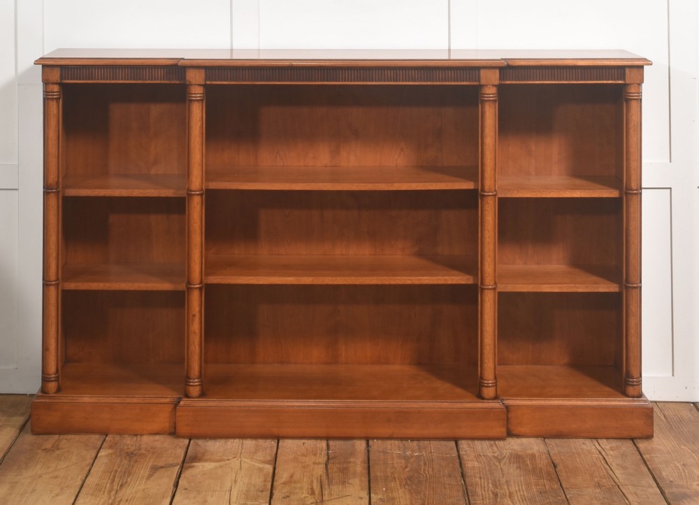 A low Regency style mahogany breakfront open bookcase featuring three shelving sections separated by reeded pilasters. View VII