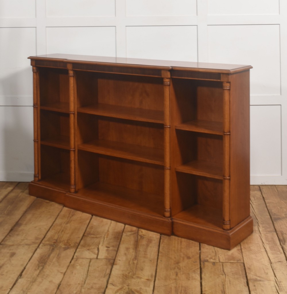A low Regency style mahogany breakfront open bookcase featuring three shelving sections separated by reeded pilasters. View VIII