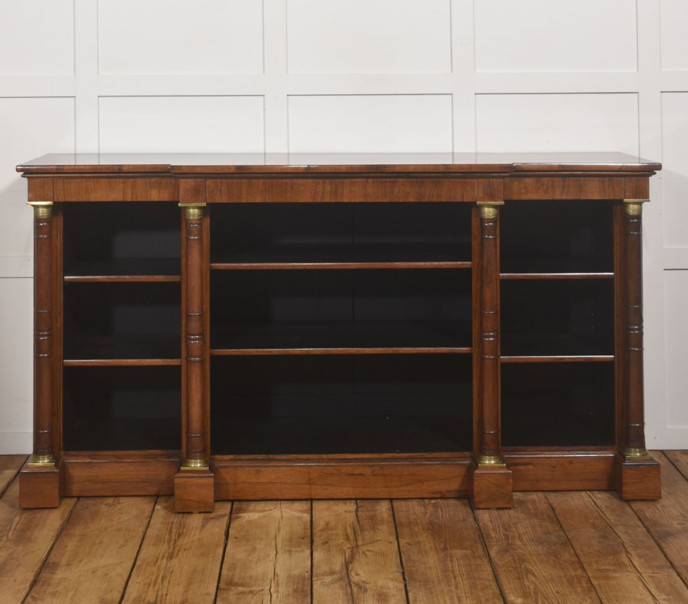 A Regency period open breakfront bookcase crafted from dark rosewood with brass mounted column pilasters and adjustable shelves. View VII