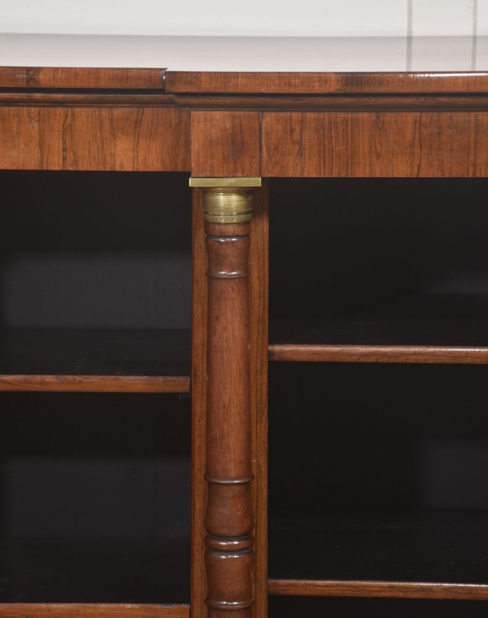 A Regency period open breakfront bookcase crafted from dark rosewood with brass mounted column pilasters and adjustable shelves. View IX