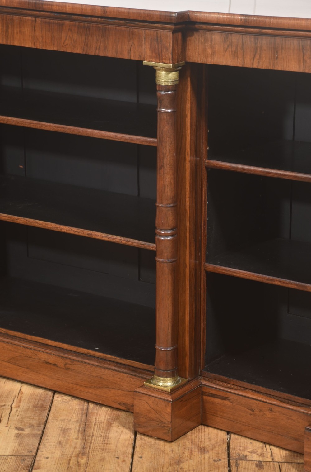 A Regency period open breakfront bookcase crafted from dark rosewood with brass mounted column pilasters and adjustable shelves. View XII