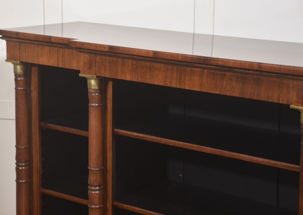 A Regency period open breakfront bookcase crafted from dark rosewood with brass mounted column pilasters and adjustable shelves. View XIII