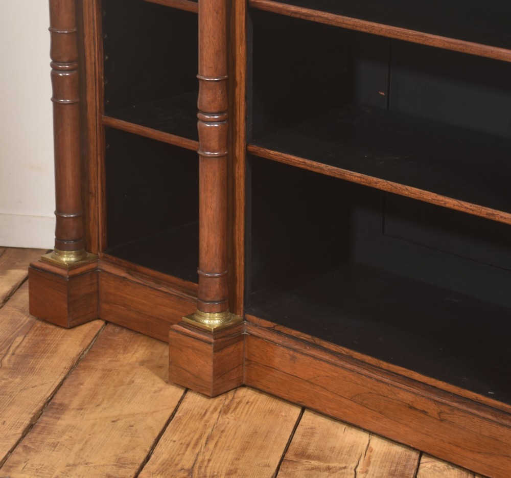 A Regency period open breakfront bookcase crafted from dark rosewood with brass mounted column pilasters and adjustable shelves. View XIV