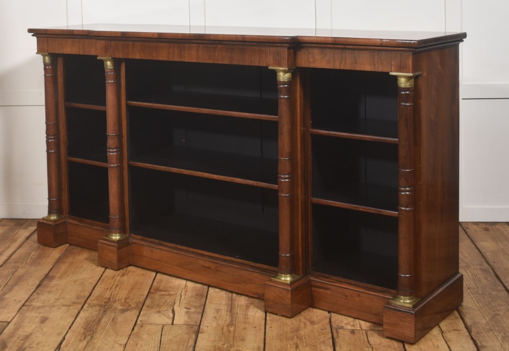 A Regency period open breakfront bookcase crafted from dark rosewood with brass mounted column pilasters and adjustable shelves. View XV