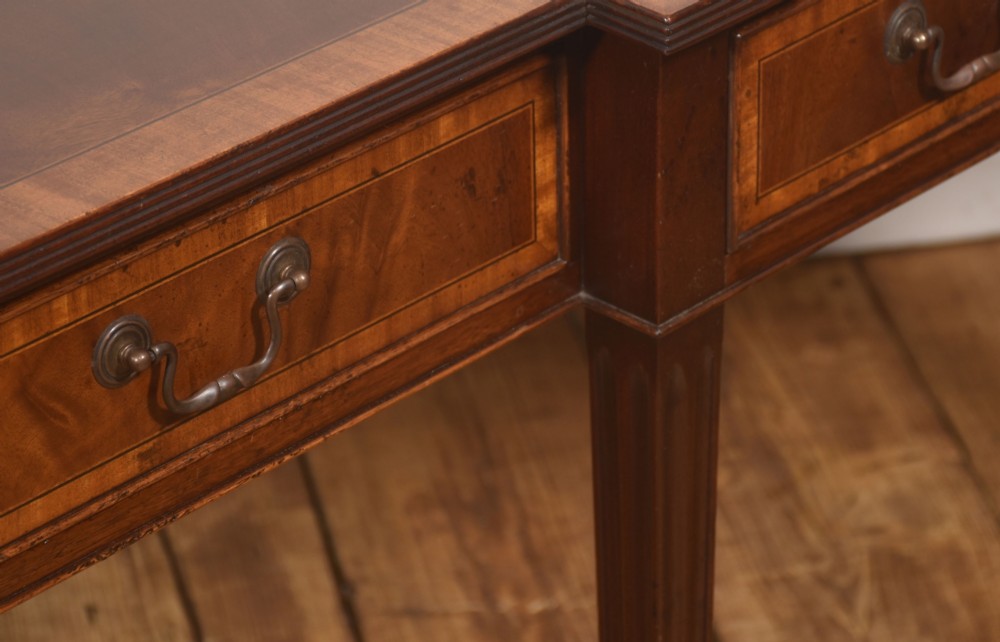 A mahogany breakfront hall table featuring satinwood crossbanding, three drawers with brass handles, and four tapered square legs. View VIII