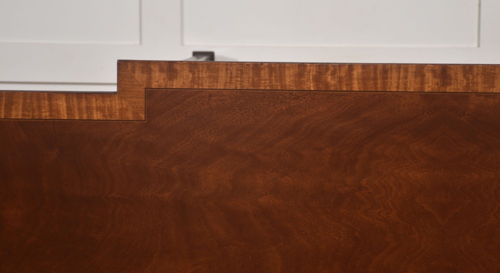 A mahogany breakfront hall table featuring satinwood crossbanding, three drawers with brass handles, and four tapered square legs. View XII
