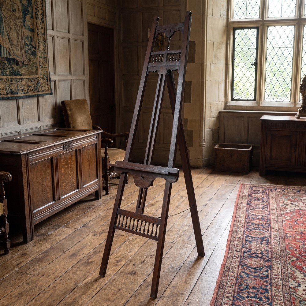 A dark walnut A-frame artist easel featuring Gothic Revival pointed arches, turned spindle galleries, and an adjustable support ledge. View II