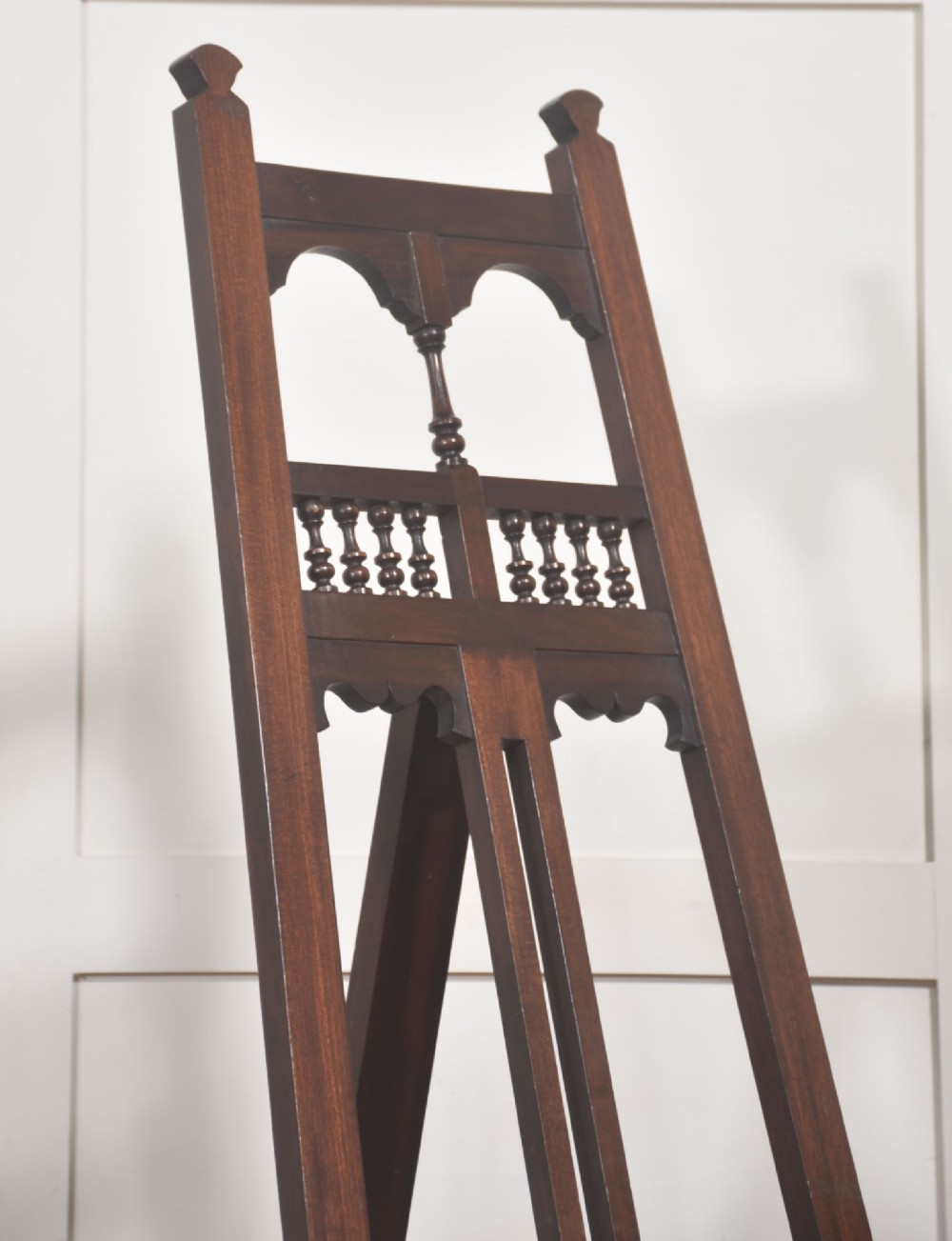 A dark walnut A-frame artist easel featuring Gothic Revival pointed arches, turned spindle galleries, and an adjustable support ledge. View III