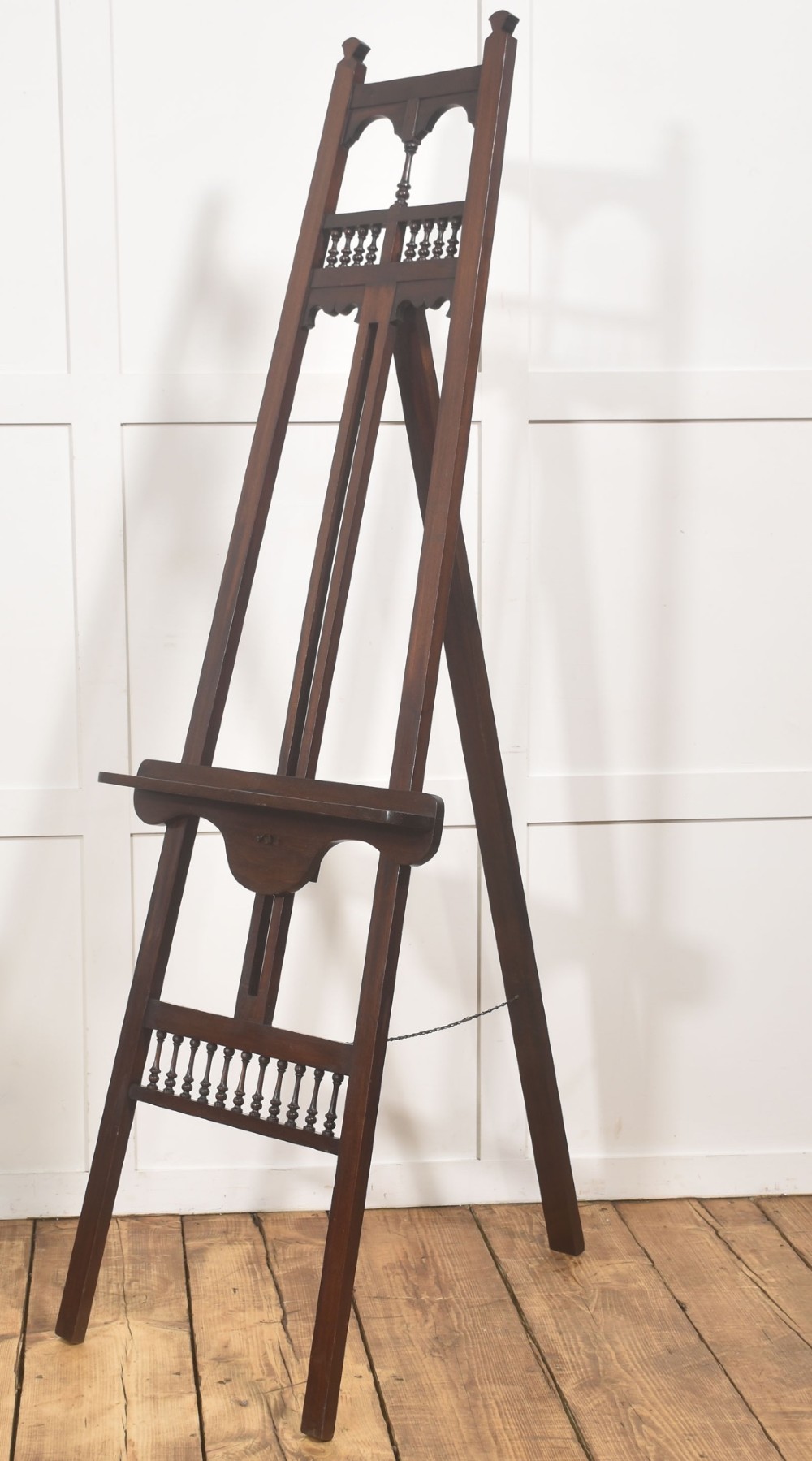 A dark walnut A-frame artist easel featuring Gothic Revival pointed arches, turned spindle galleries, and an adjustable support ledge. View VI