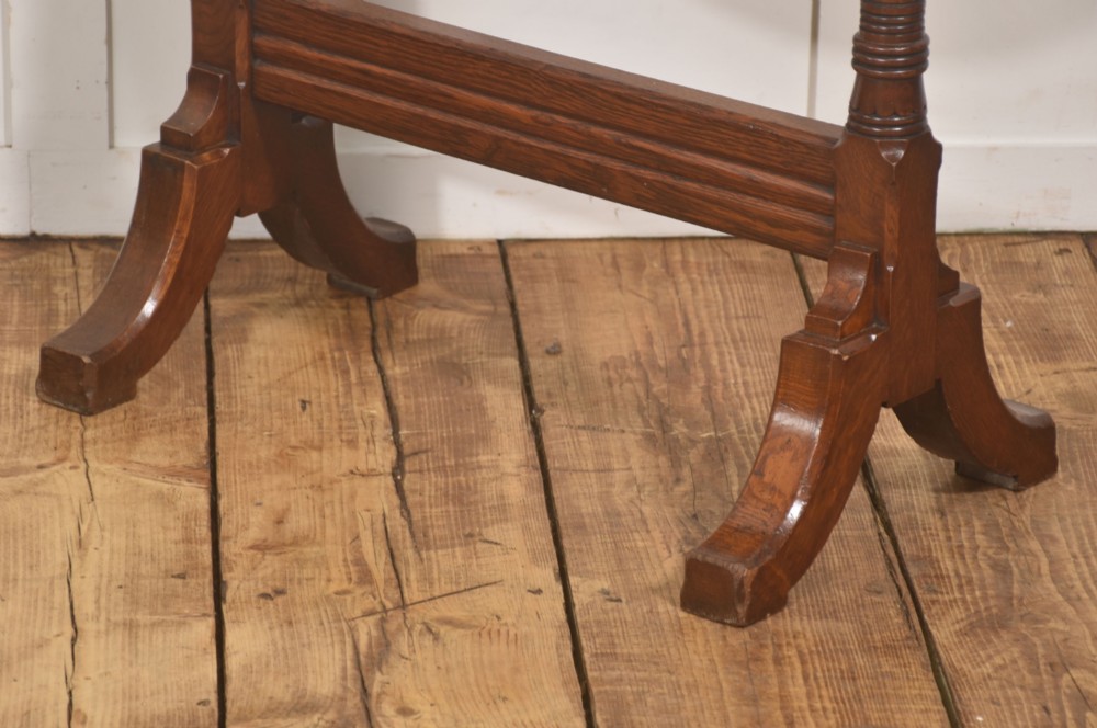 A standing dark oak frame featuring turned upright pillars, top spindles, and a central suspended hammered brass dinner gong dish with a hanging mallet. View XI