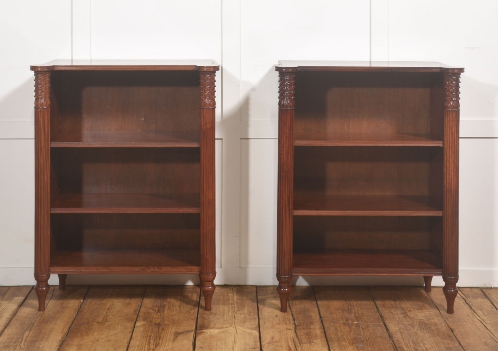 A pair of low mahogany open bookcases featuring fluted pilasters with carved tops, adjustable shelves, and turned legs. View II