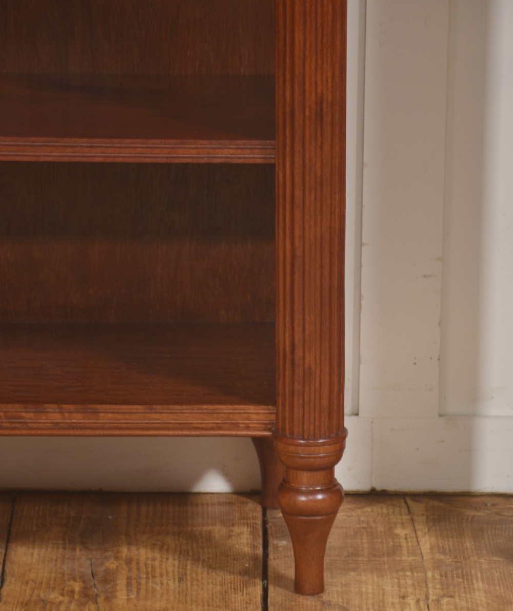 A pair of low mahogany open bookcases featuring fluted pilasters with carved tops, adjustable shelves, and turned legs. View IV