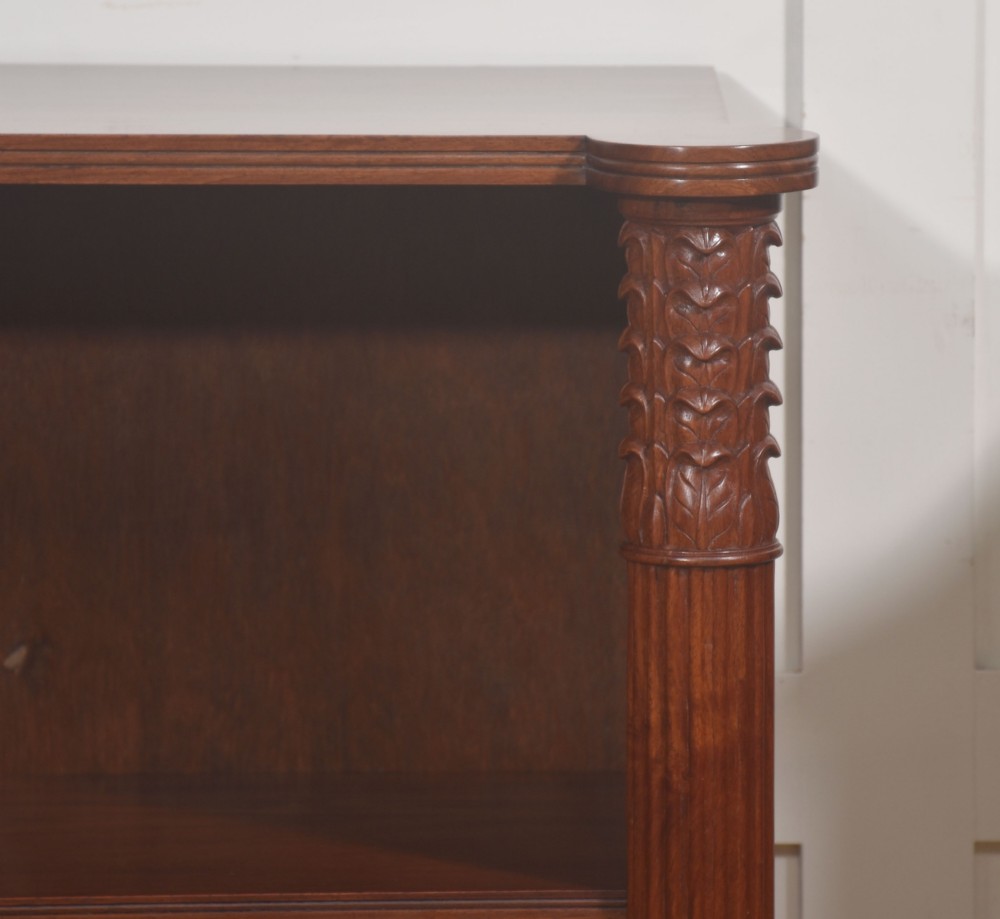 A pair of low mahogany open bookcases featuring fluted pilasters with carved tops, adjustable shelves, and turned legs. View V