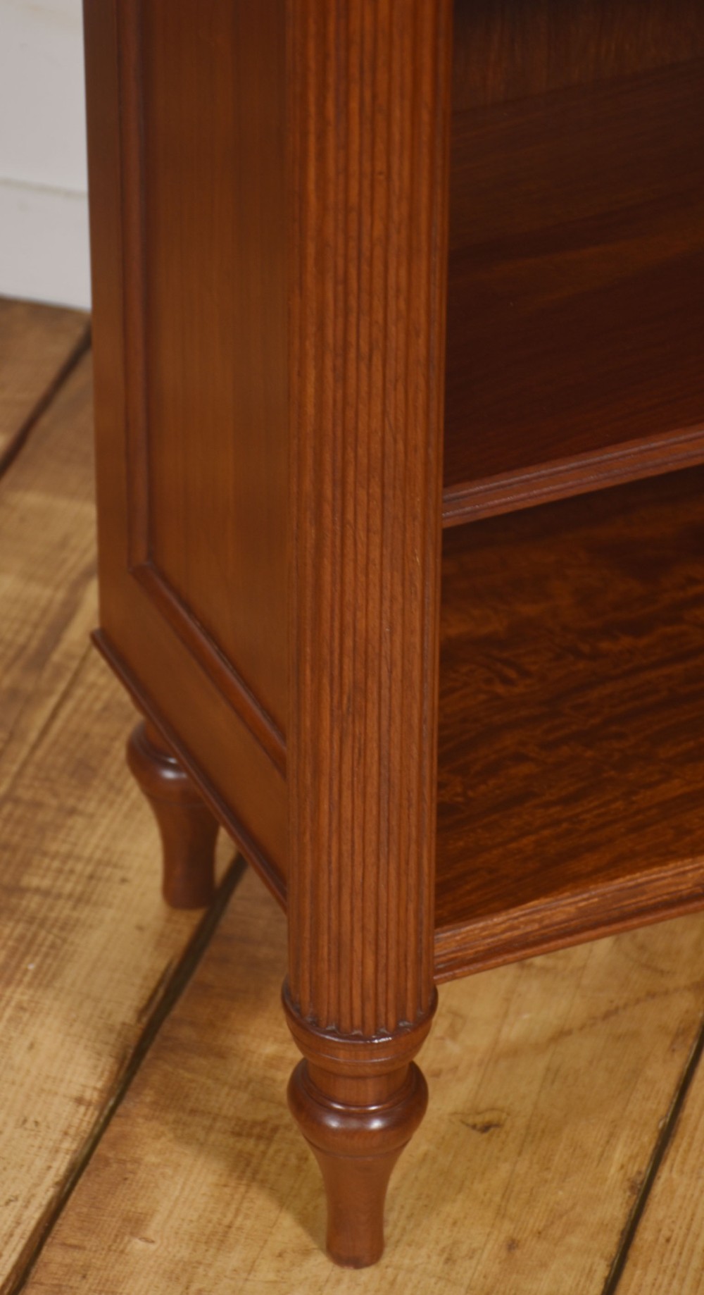 A pair of low mahogany open bookcases featuring fluted pilasters with carved tops, adjustable shelves, and turned legs. View VIII