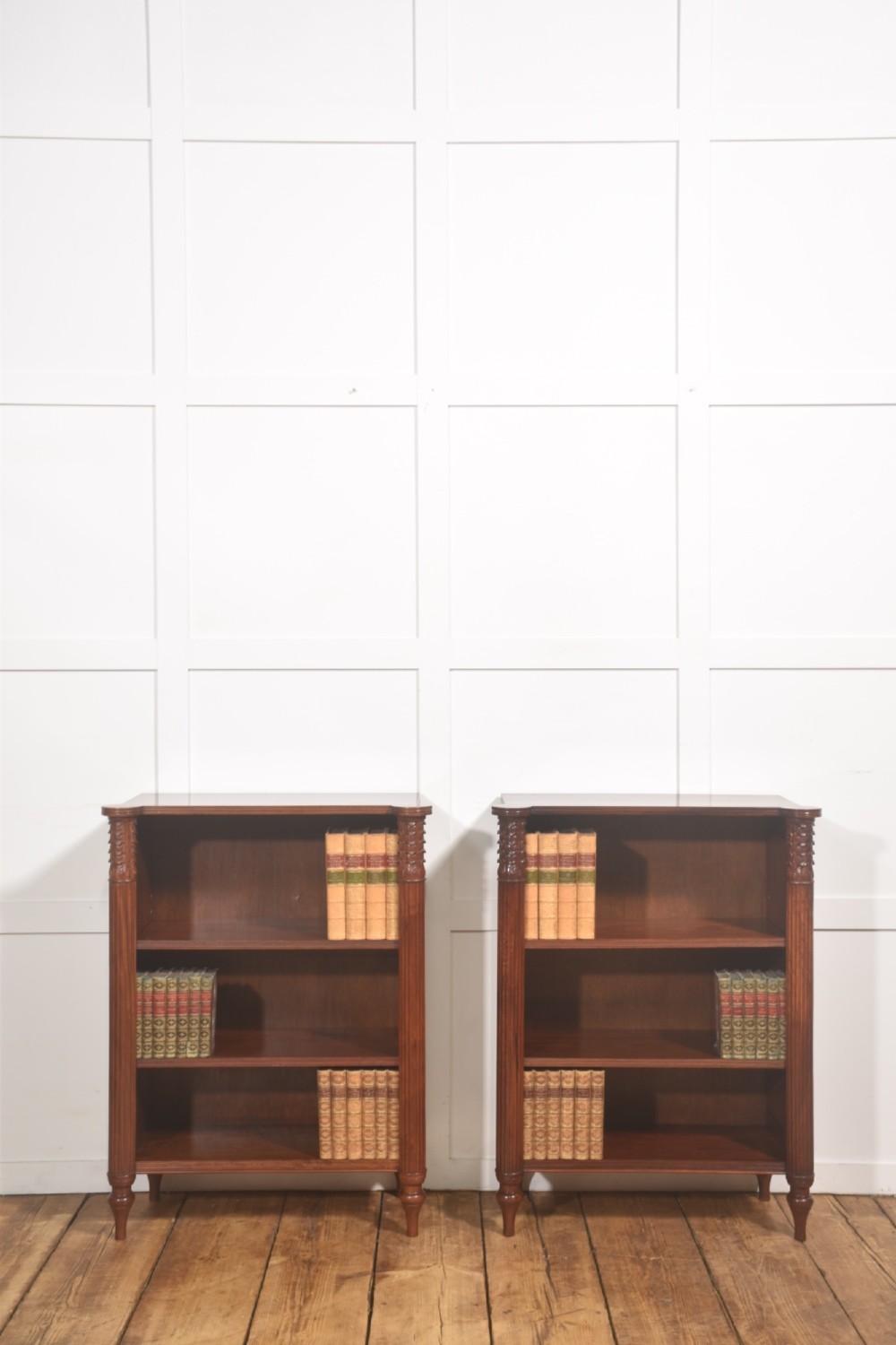 A pair of low mahogany open bookcases featuring fluted pilasters with carved tops, adjustable shelves, and turned legs. View IX