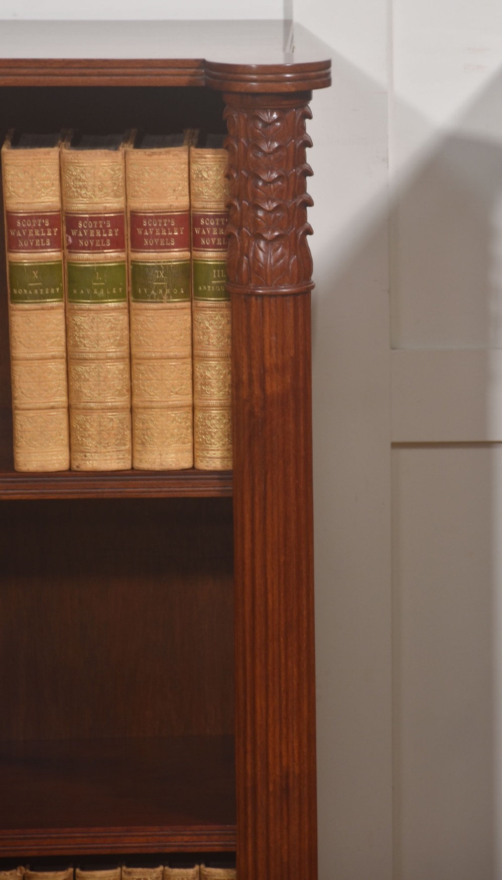 A pair of low mahogany open bookcases featuring fluted pilasters with carved tops, adjustable shelves, and turned legs. View X