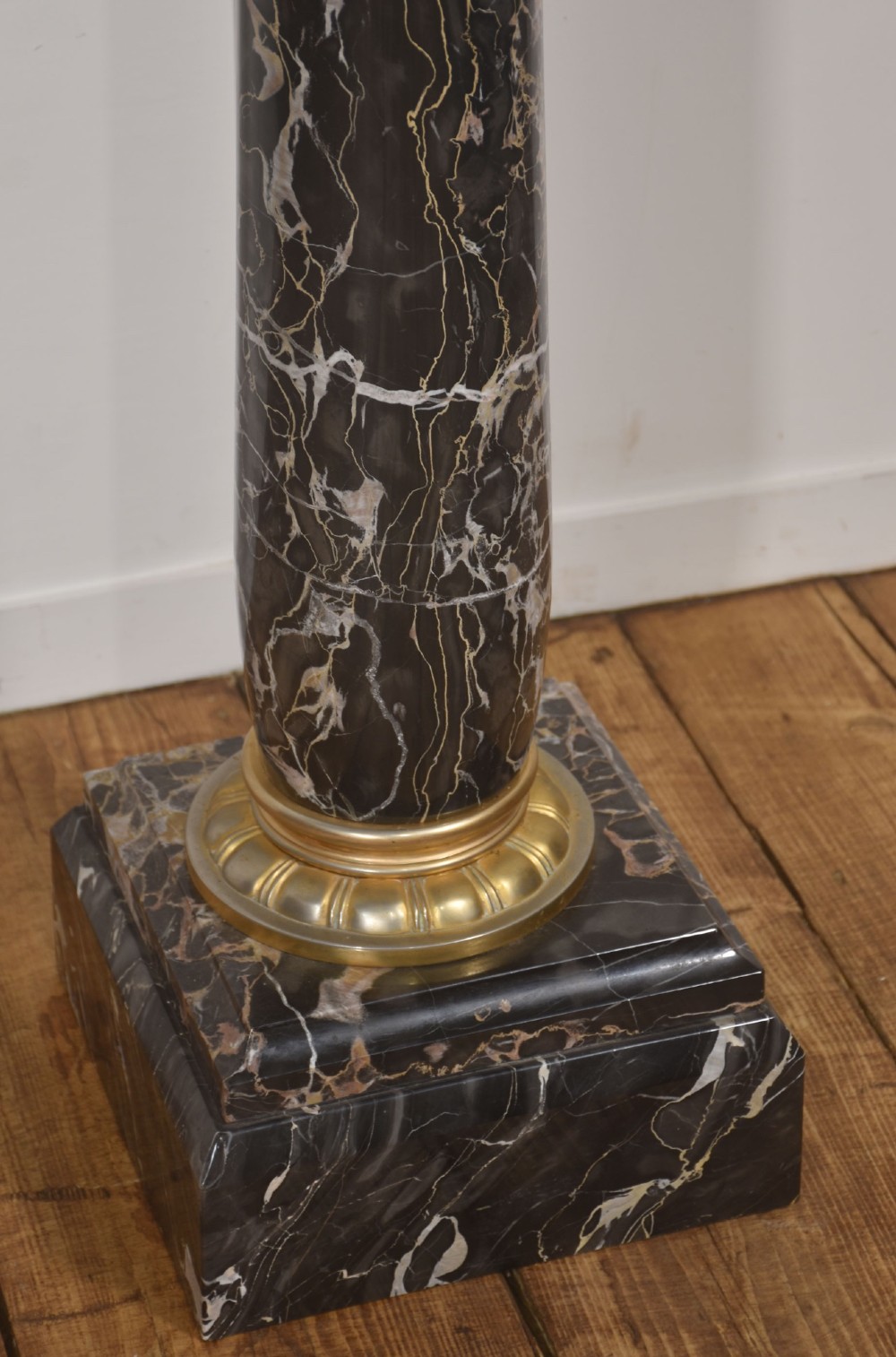 A black veined-marble urn with two handles and gilt-metal mounts resting on a matching cylindrical black marble pedestal with a Corinthian capital. View VII