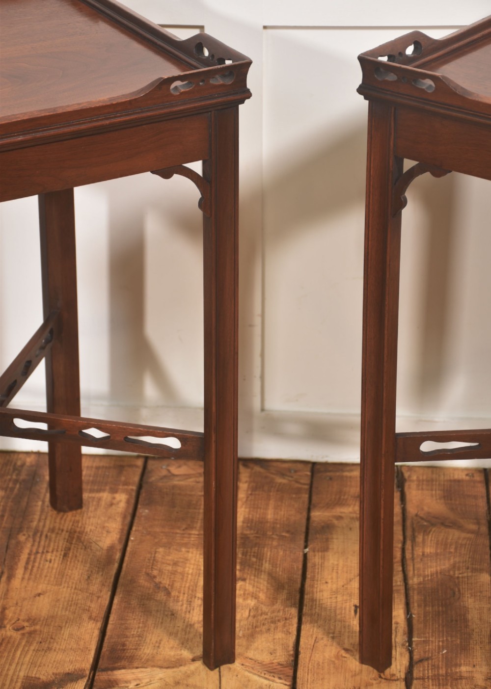 A pair of dark mahogany Edwardian side tables with square tops, pierced fretwork galleries, and cross stretchers. View IV