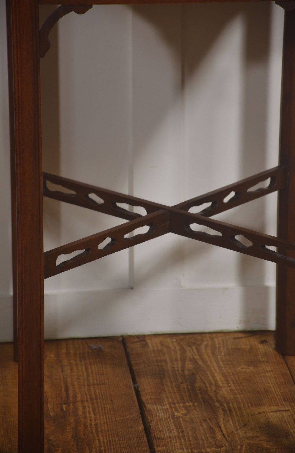 A pair of dark mahogany Edwardian side tables with square tops, pierced fretwork galleries, and cross stretchers. View VII