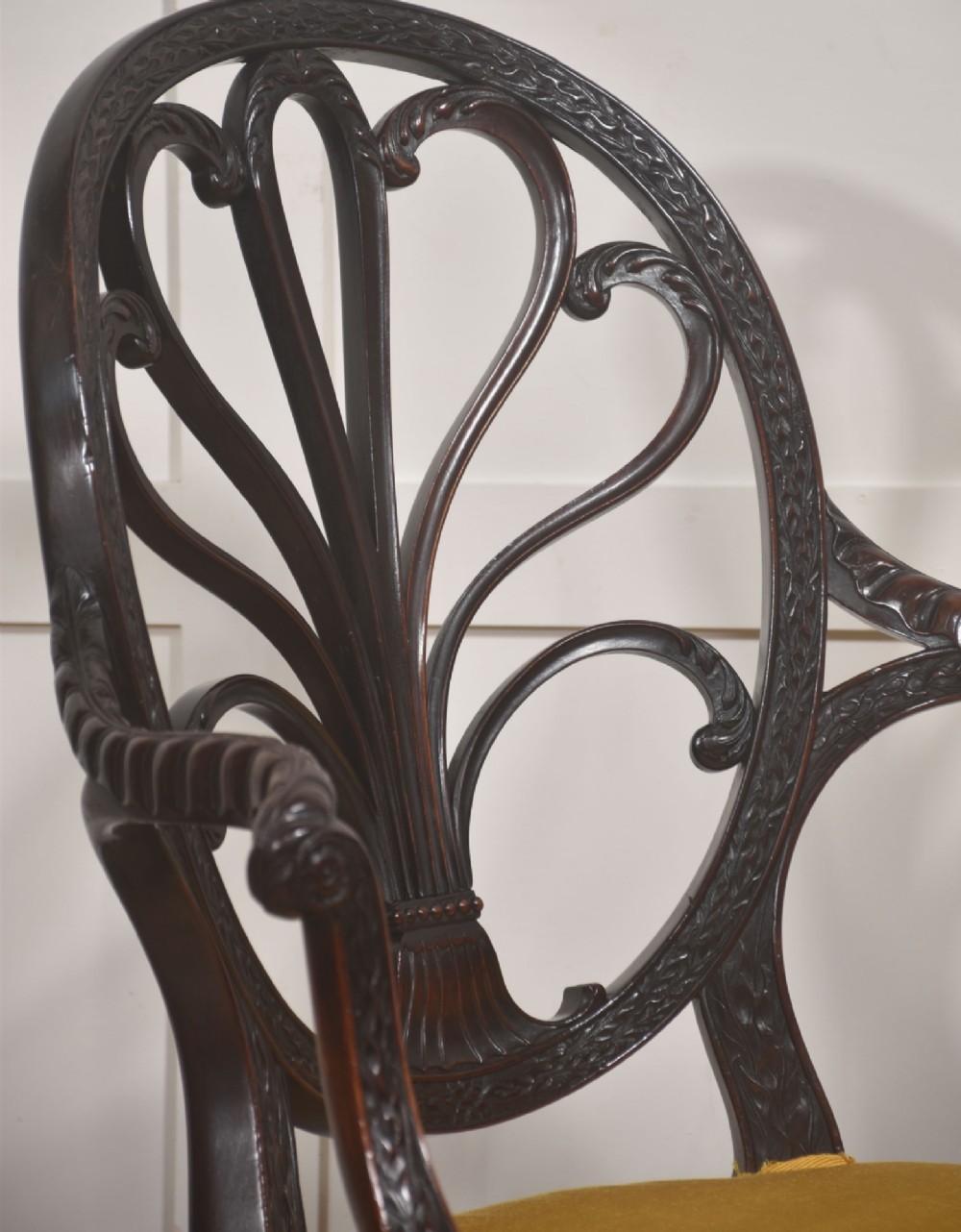 A carved mahogany open armchair featuring an oval wheat-sheaf backrest, swept arms, and a yellow upholstered seat secured with brass studs. View VIII