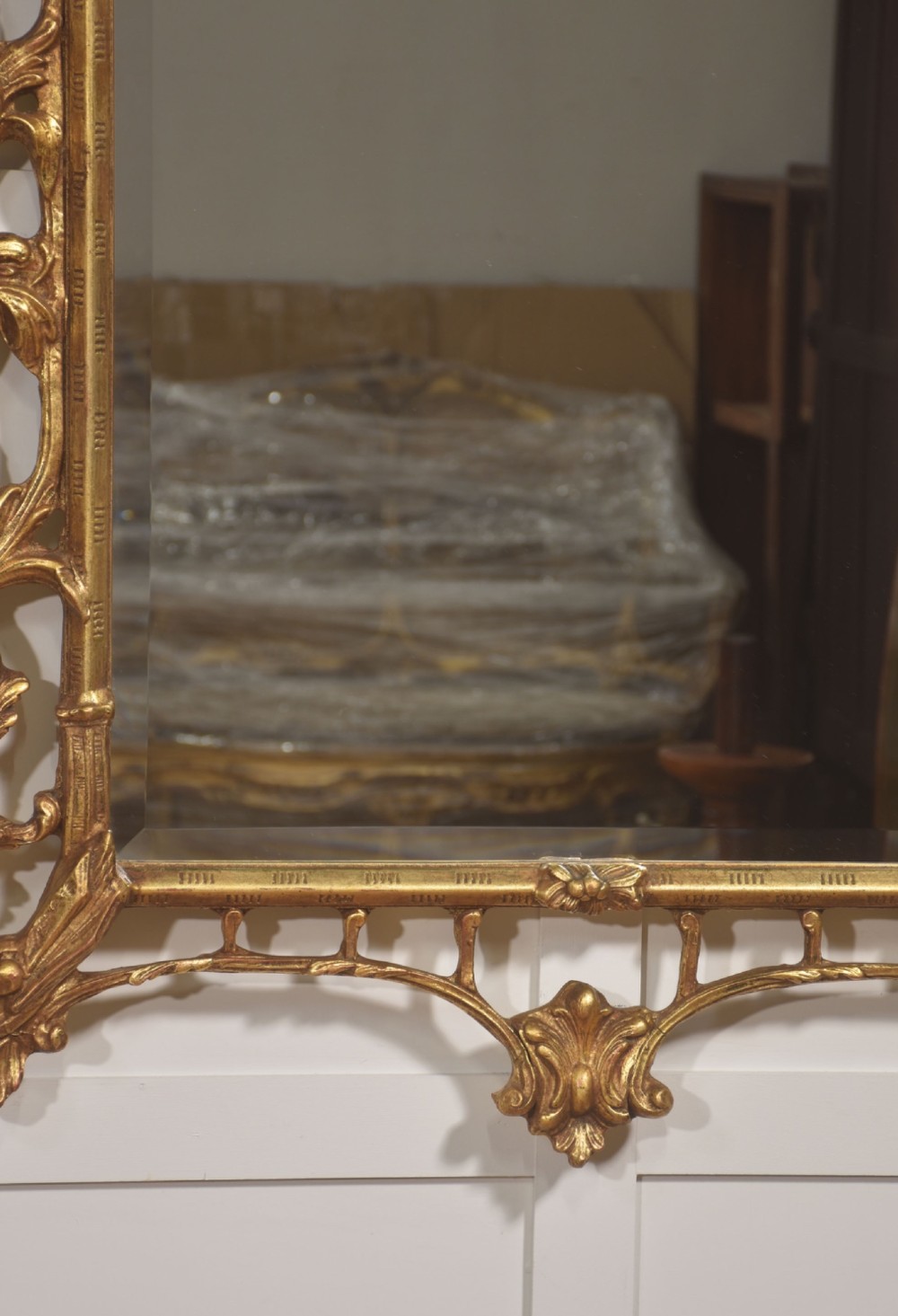 A rectangular wall mirror with a bevelled glass edge framed in elaborate carved gold giltwood featuring scrolls and acanthus motifs. View VIII