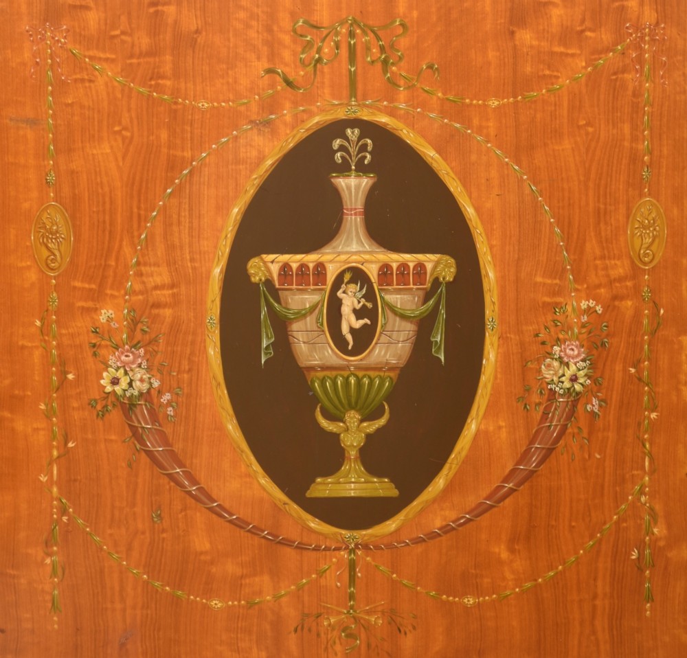 A pair of golden satinwood demi-lune cabinets featuring central hand-painted oval urn motifs and tapered legs. View VIII