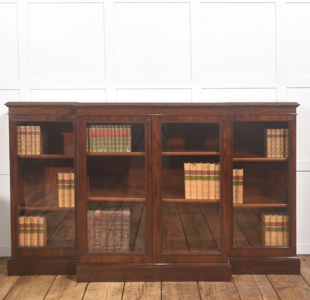 A 19th-century mahogany breakfront library bookcase featuring four glass-panelled doors, adjustable interior shelving, and a moulded cornice.