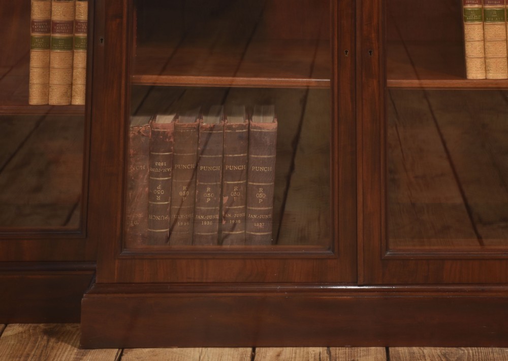 A 19th-century mahogany breakfront library bookcase featuring four glass-panelled doors, adjustable interior shelving, and a moulded cornice. View IV
