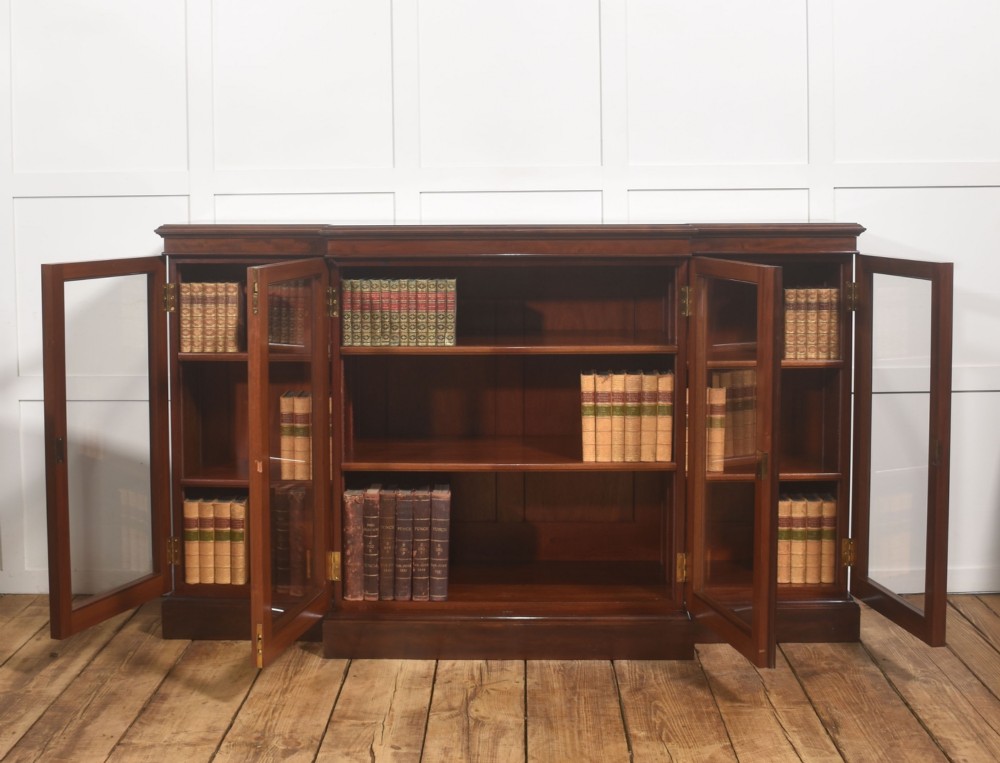 A 19th-century mahogany breakfront library bookcase featuring four glass-panelled doors, adjustable interior shelving, and a moulded cornice. View V