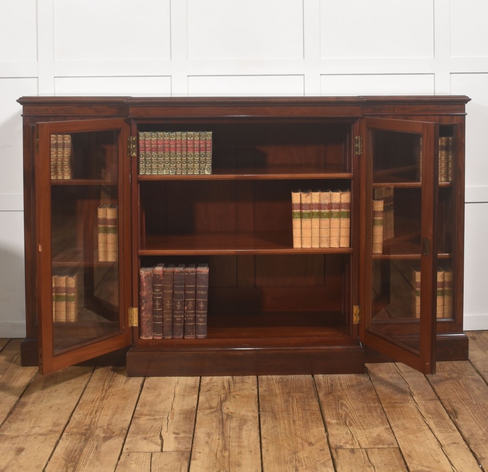 A 19th-century mahogany breakfront library bookcase featuring four glass-panelled doors, adjustable interior shelving, and a moulded cornice. View VI