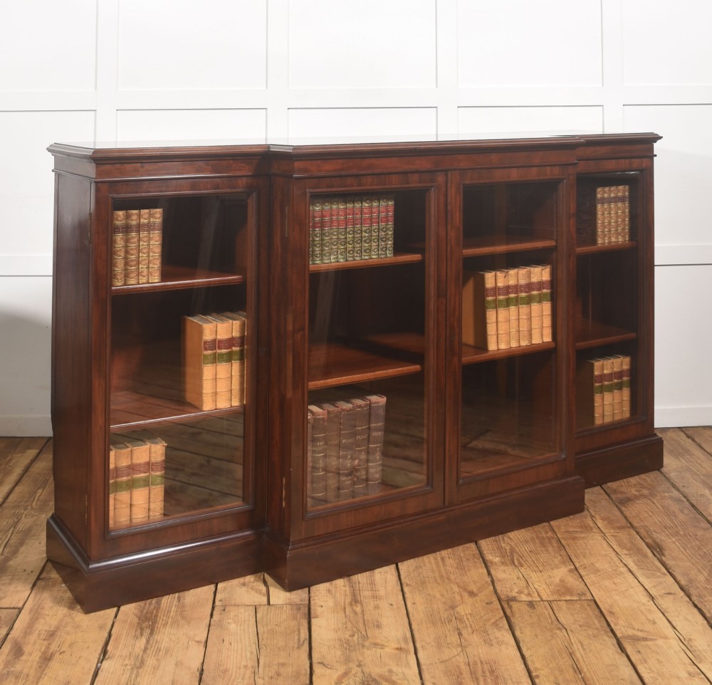 A 19th-century mahogany breakfront library bookcase featuring four glass-panelled doors, adjustable interior shelving, and a moulded cornice. View VII