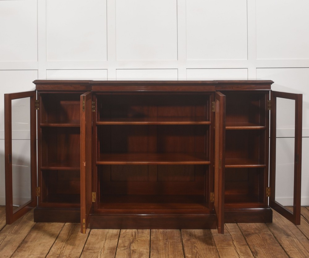 A 19th-century mahogany breakfront library bookcase featuring four glass-panelled doors, adjustable interior shelving, and a moulded cornice. View IX