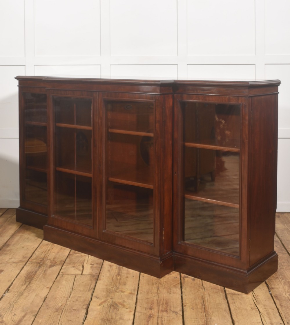 A 19th-century mahogany breakfront library bookcase featuring four glass-panelled doors, adjustable interior shelving, and a moulded cornice. View XIII