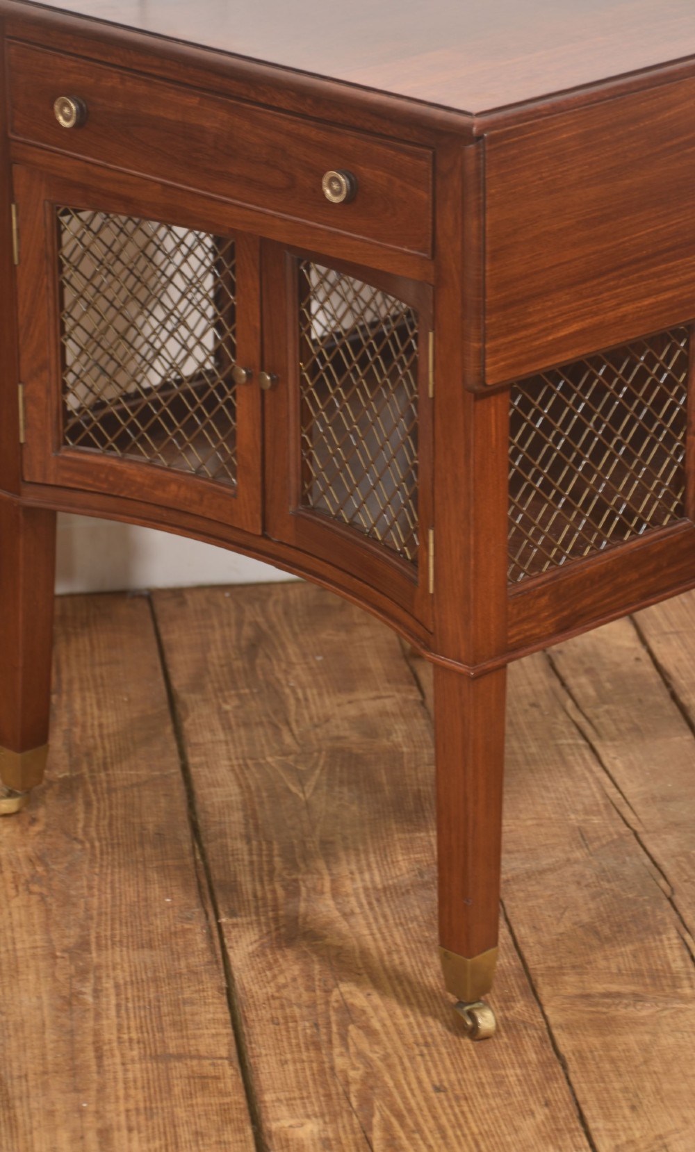 A pair of rosewood drop-leaf side tables featuring single drawers above cupboard doors with brass grille inserts, standing on square tapered legs with brass castors. View III