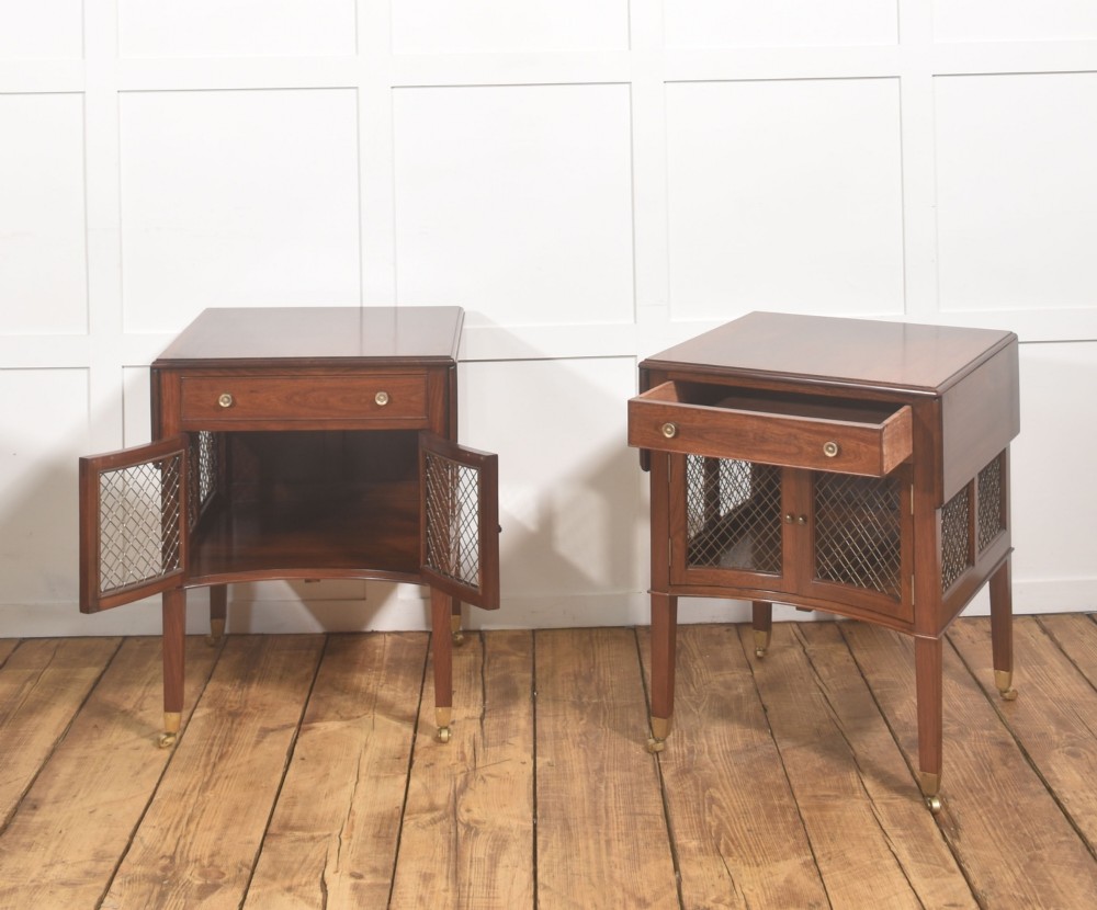 A pair of rosewood drop-leaf side tables featuring single drawers above cupboard doors with brass grille inserts, standing on square tapered legs with brass castors. View VI